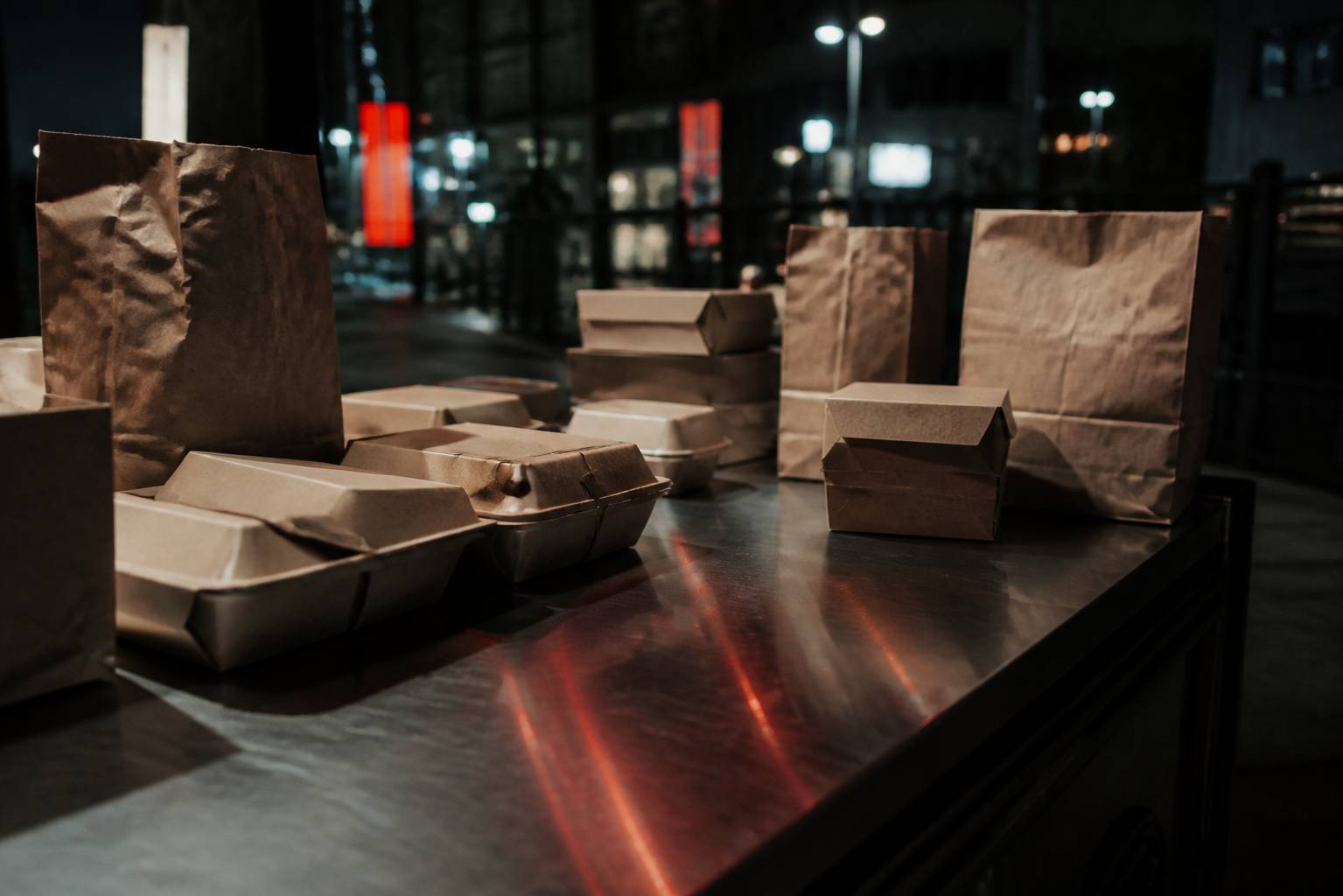 Plans de travail en acier avec boîtes de repas et sachets kraft