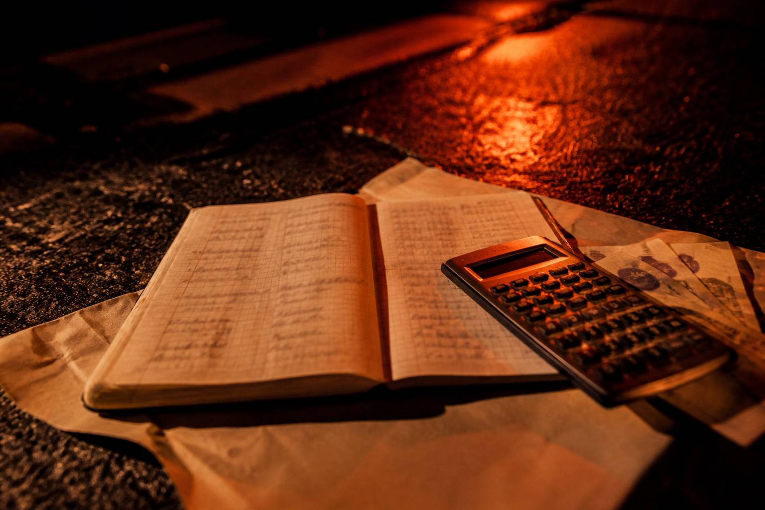 Carnet de comptes et calculatrice sur papier kraft avec des billets, chiffres sans texte lisible