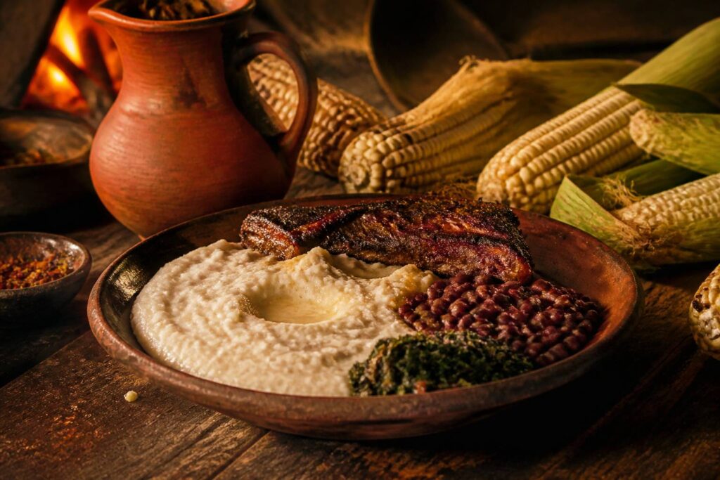 Bouillie de maïs sishwala avec haricots et viande grillée servie dans un plat de terre